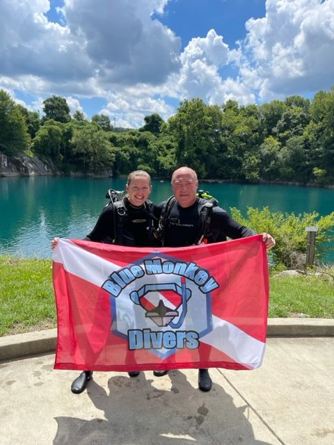Świeżo certyfikowany nurek i Coach McCain z flagą Blue Monkey Divers